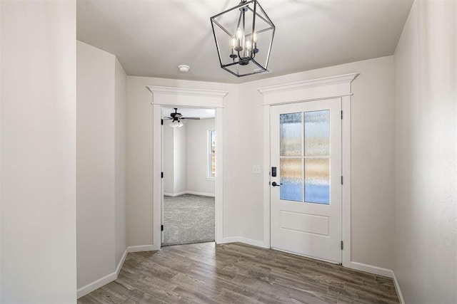 foyer entrance featuring ceiling fan with notable chandelier and wood-type flooring