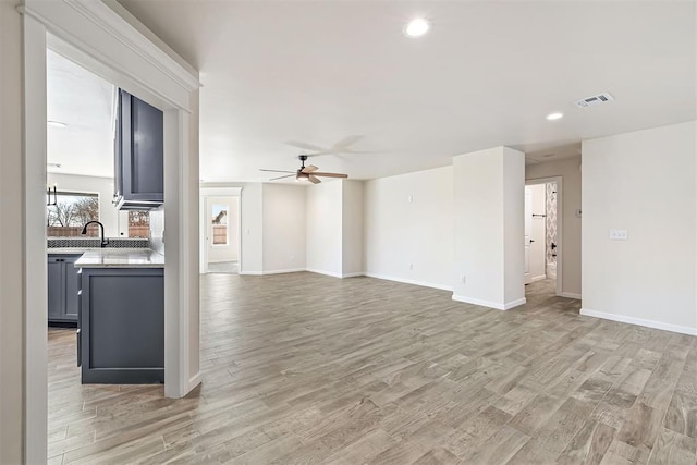 unfurnished living room with ceiling fan and light hardwood / wood-style floors