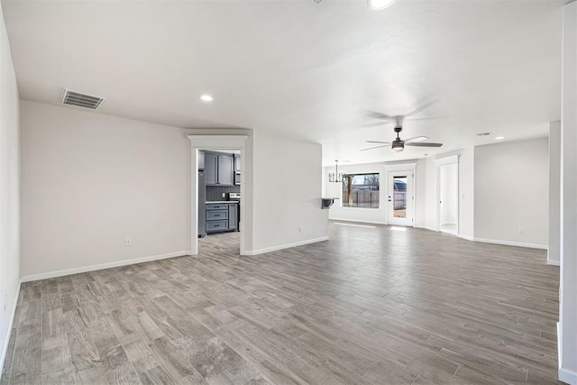 unfurnished living room with ceiling fan and light wood-type flooring