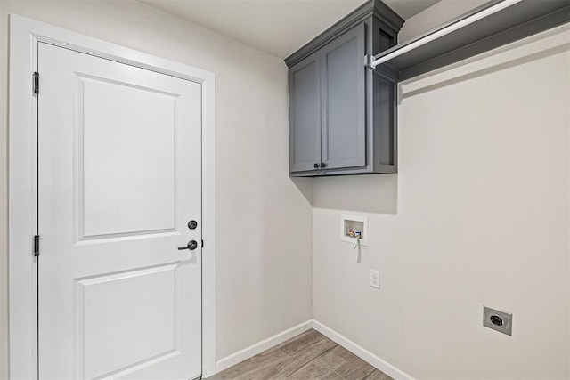 washroom with hookup for a washing machine, cabinets, light hardwood / wood-style flooring, and hookup for an electric dryer