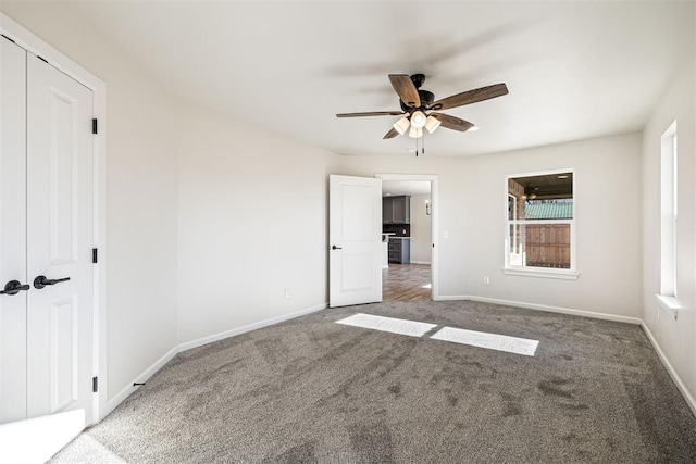 unfurnished bedroom featuring ceiling fan, a closet, and carpet