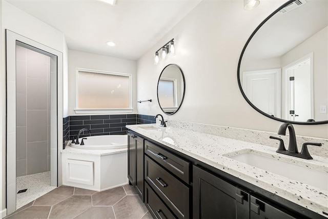 bathroom with tile walls, tile patterned floors, vanity, and plus walk in shower