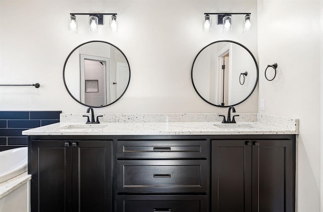 bathroom featuring a washtub and vanity