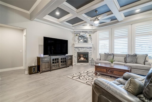 living room with a tile fireplace, coffered ceiling, ceiling fan, light hardwood / wood-style floors, and crown molding