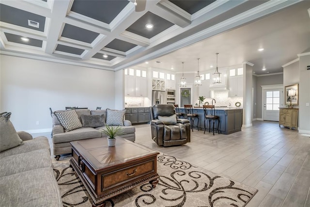 living room featuring ornamental molding, coffered ceiling, beam ceiling, and a notable chandelier