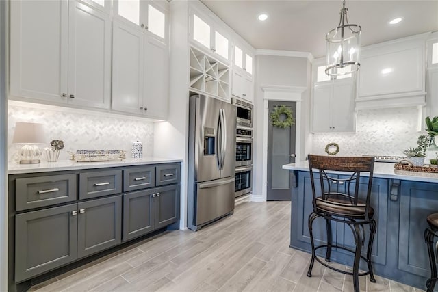 kitchen with decorative light fixtures, gray cabinets, stainless steel appliances, and white cabinets