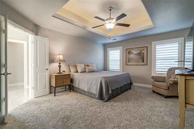 bedroom with ceiling fan, a raised ceiling, and light colored carpet