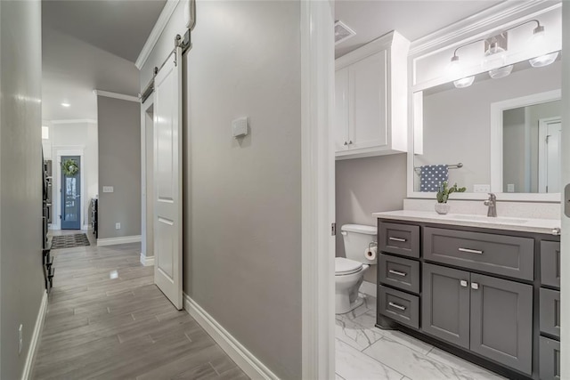 bathroom with vanity, ornamental molding, and toilet