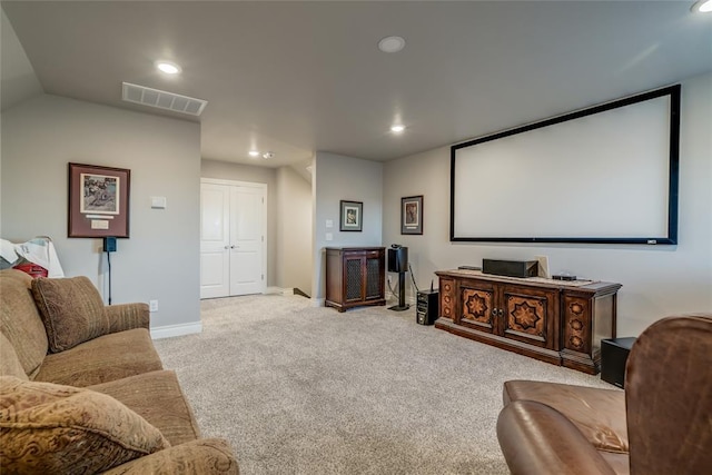 home theater room with lofted ceiling and light carpet