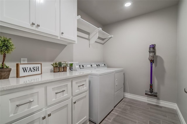 laundry room with cabinets, washer and dryer, and light wood-type flooring