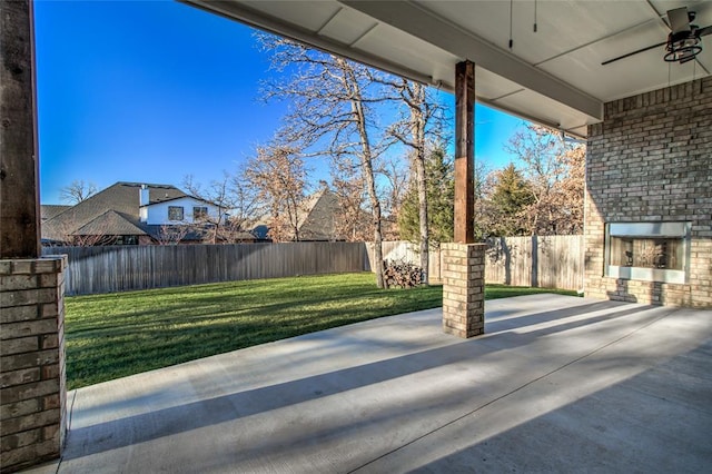 view of patio / terrace featuring an outdoor brick fireplace and ceiling fan