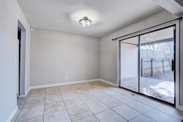 tiled spare room with a textured ceiling