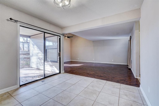 tiled spare room with ceiling fan and beamed ceiling