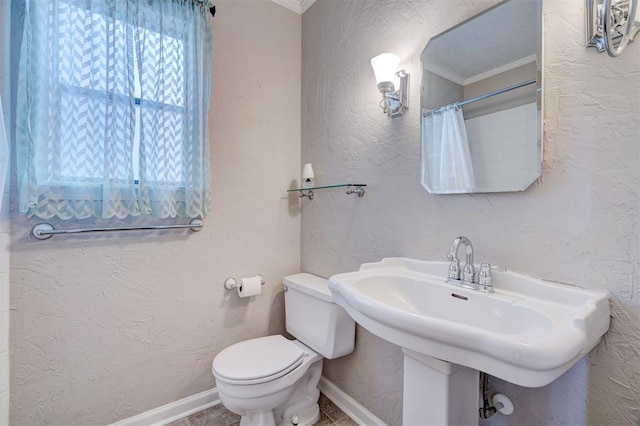 bathroom with toilet, ornamental molding, walk in shower, and sink