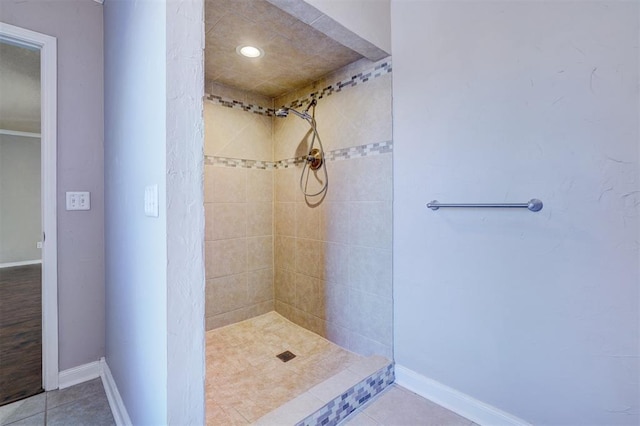 bathroom with tiled shower and tile patterned floors