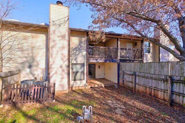 back of house featuring cooling unit and a deck