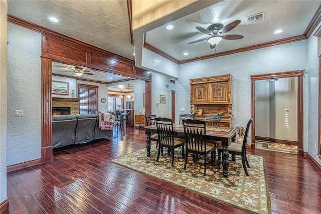 dining space featuring a textured ceiling, ceiling fan, ornamental molding, and dark hardwood / wood-style floors