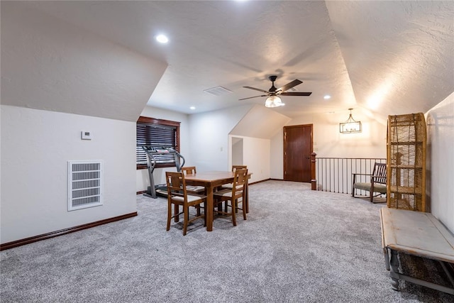 dining area with ceiling fan with notable chandelier, a textured ceiling, carpet floors, and vaulted ceiling