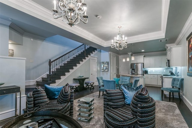 living room featuring a raised ceiling, dark wood-type flooring, a notable chandelier, and ornamental molding