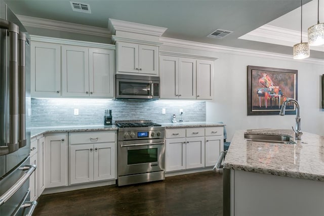 kitchen featuring white cabinets, light stone counters, high quality appliances, and sink