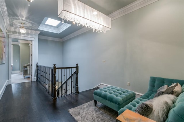 living area with a skylight, dark hardwood / wood-style floors, and ornamental molding