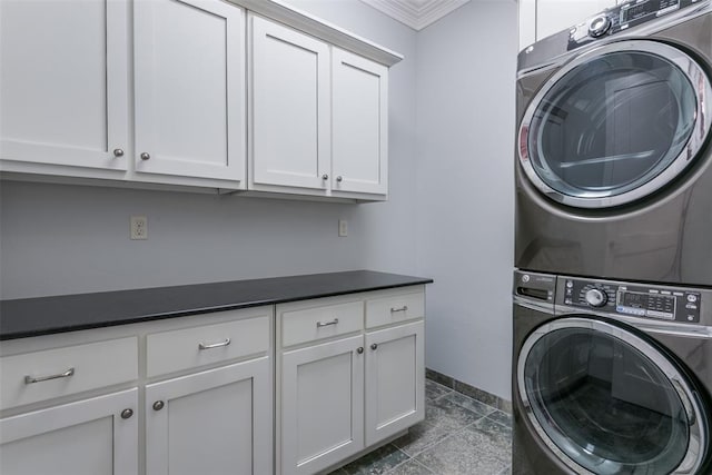 washroom featuring cabinets, ornamental molding, and stacked washer and clothes dryer