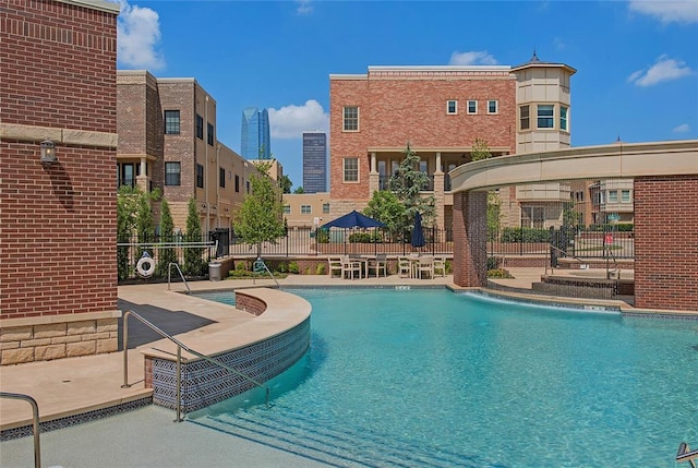 view of swimming pool with pool water feature and a patio area