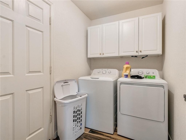 laundry room with washer and clothes dryer, cabinets, and dark hardwood / wood-style floors