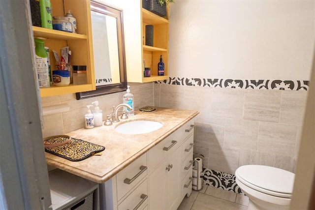 bathroom featuring tile patterned floors, vanity, toilet, and tile walls