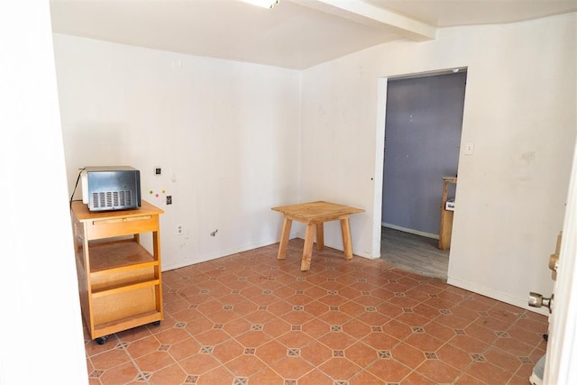 empty room featuring beamed ceiling