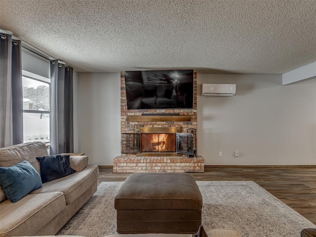 living room featuring a textured ceiling, a wall mounted AC, hardwood / wood-style floors, and a fireplace