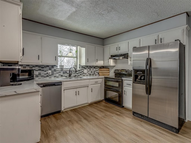 kitchen with a textured ceiling, stainless steel appliances, light wood-type flooring, white cabinetry, and sink