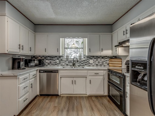 kitchen featuring black appliances, white cabinets, decorative backsplash, and sink