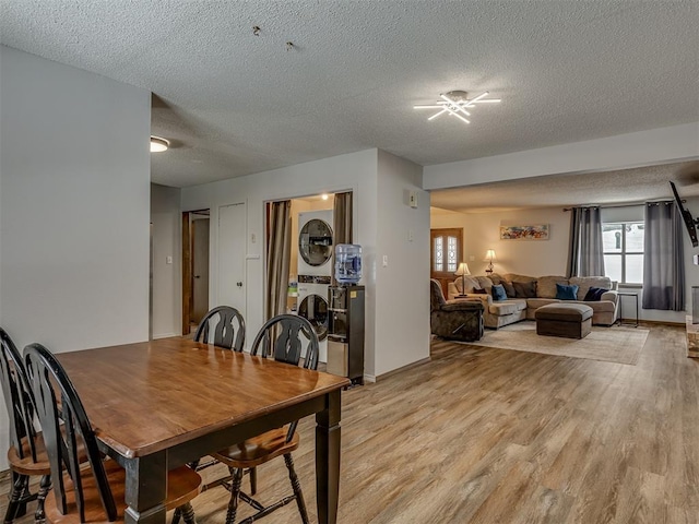 dining area featuring a textured ceiling and light wood-type flooring