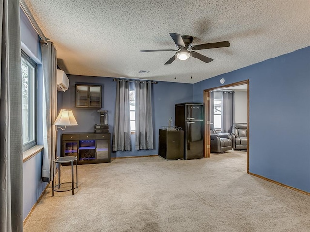 interior space with a textured ceiling, ceiling fan, and carpet flooring