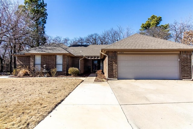 ranch-style house featuring a shingled roof, concrete driveway, brick siding, and an attached garage