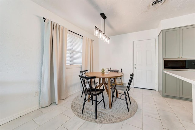 tiled dining space with a textured ceiling