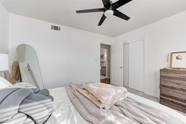 carpeted bedroom with ceiling fan and a closet