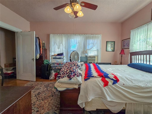 bedroom featuring multiple windows, a textured ceiling, and ceiling fan