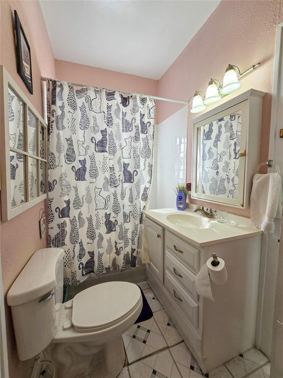 bathroom with toilet, vanity, and tile patterned flooring