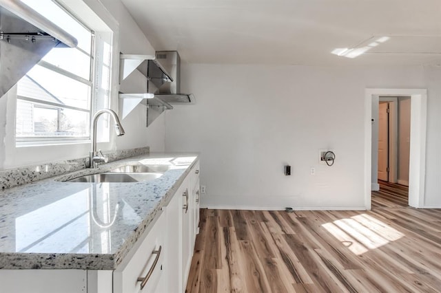 laundry area featuring sink and light hardwood / wood-style floors