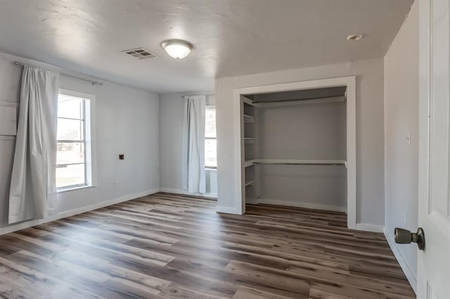 unfurnished bedroom featuring dark hardwood / wood-style flooring and a closet