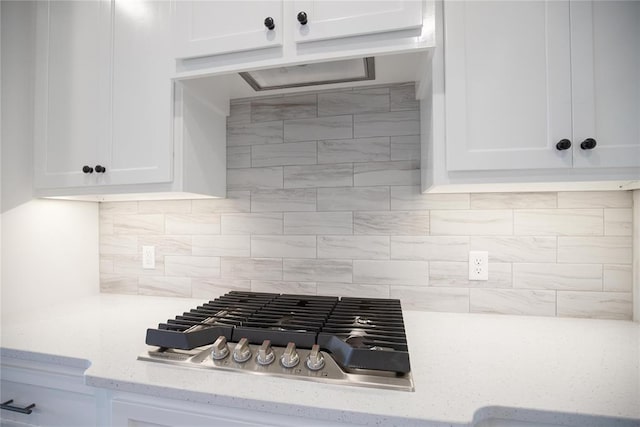 8108 NW 154th St, Edmond, OK 73013 - kitchen with stainless steel gas cooktop, white cabinets, backsplash, and light stone countertops