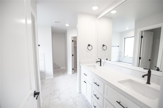 8108 NW 154th St, Edmond, OK 73013 - full bathroom featuring marble look tile flooring, double vanity, recessed lighting, baseboards, and a walk in closet