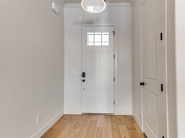 entryway with crown molding and light hardwood / wood-style floors