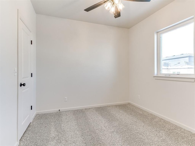 carpeted spare room featuring ceiling fan