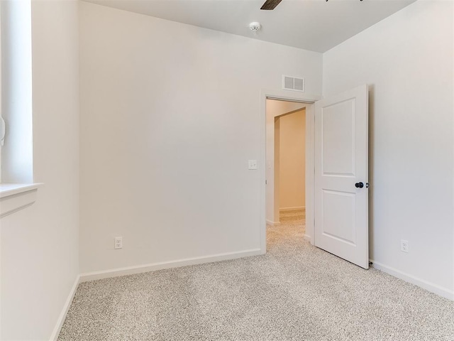 unfurnished room featuring light carpet and ceiling fan