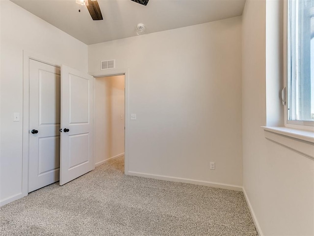 unfurnished bedroom featuring light carpet and ceiling fan