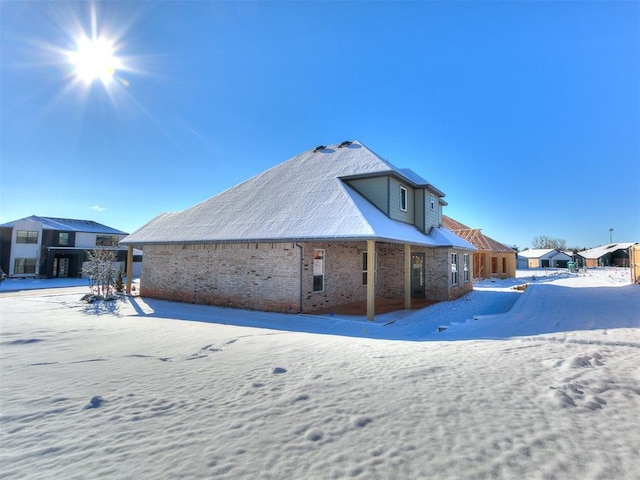 view of snow covered back of property