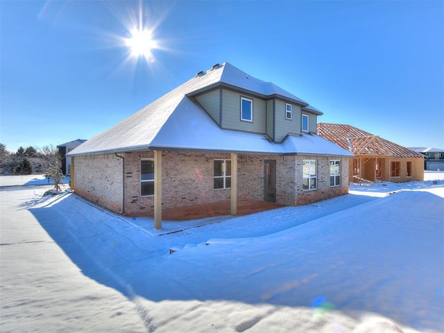 view of snow covered back of property